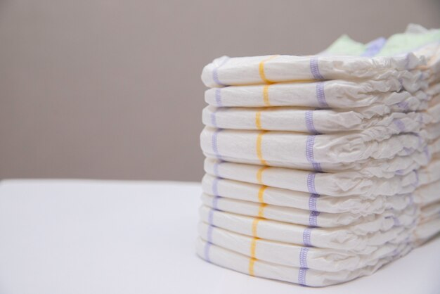 Baby diapers in a stack on a white background. Hygiene of the baby.